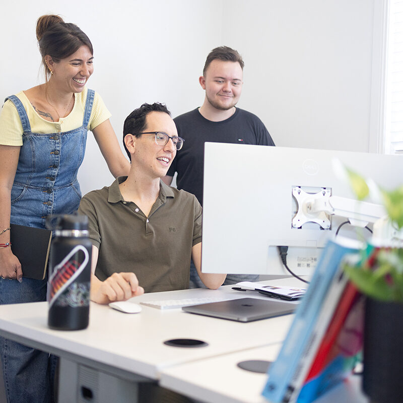 Raquel, Juan and Callum discussing marketing reports for clients